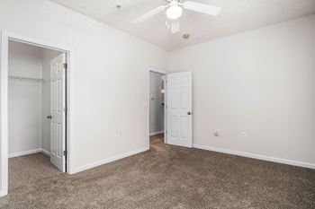Spacious Carpeted Bedroom With Ceiling Fan